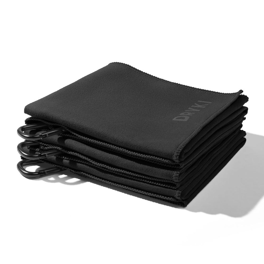 Stack of black microfiber cloths with carabiners on a white background, DRYKI Pocket-sized sweat towel (sweat absorbing handkerchief)
